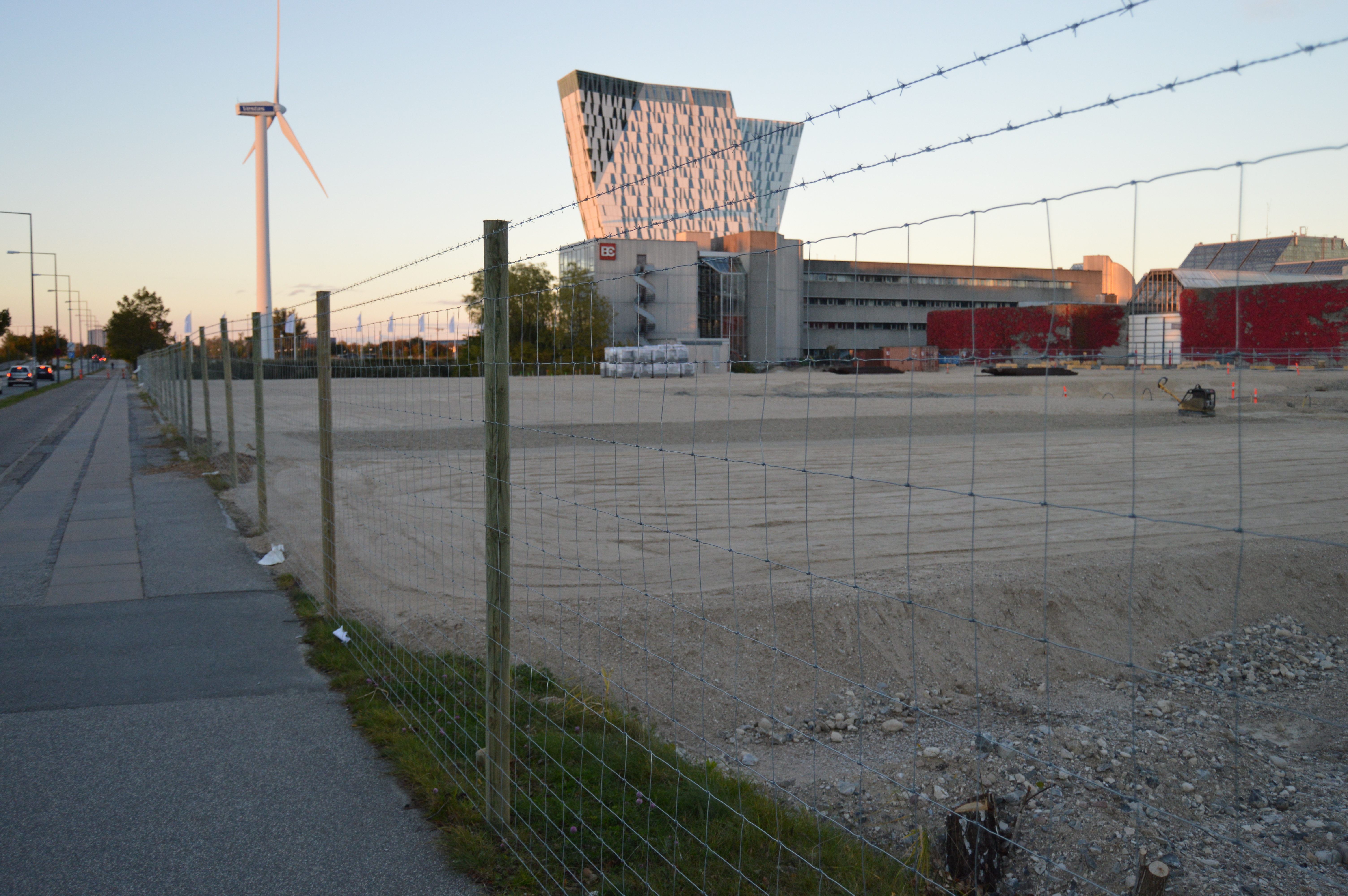 En byggeplads er beskyttet med et nethegn med to pigtråde monteret ovenpå
