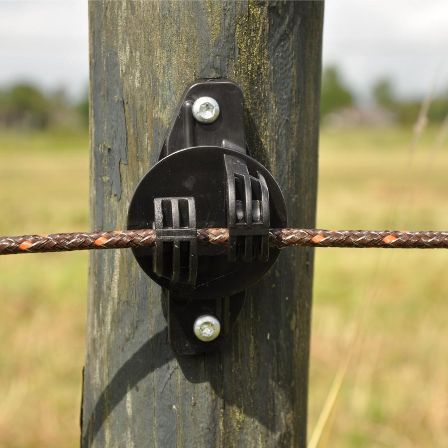 En eltråd til et elhegn holdes på plads af en isolator monteret på en hegnspæl.