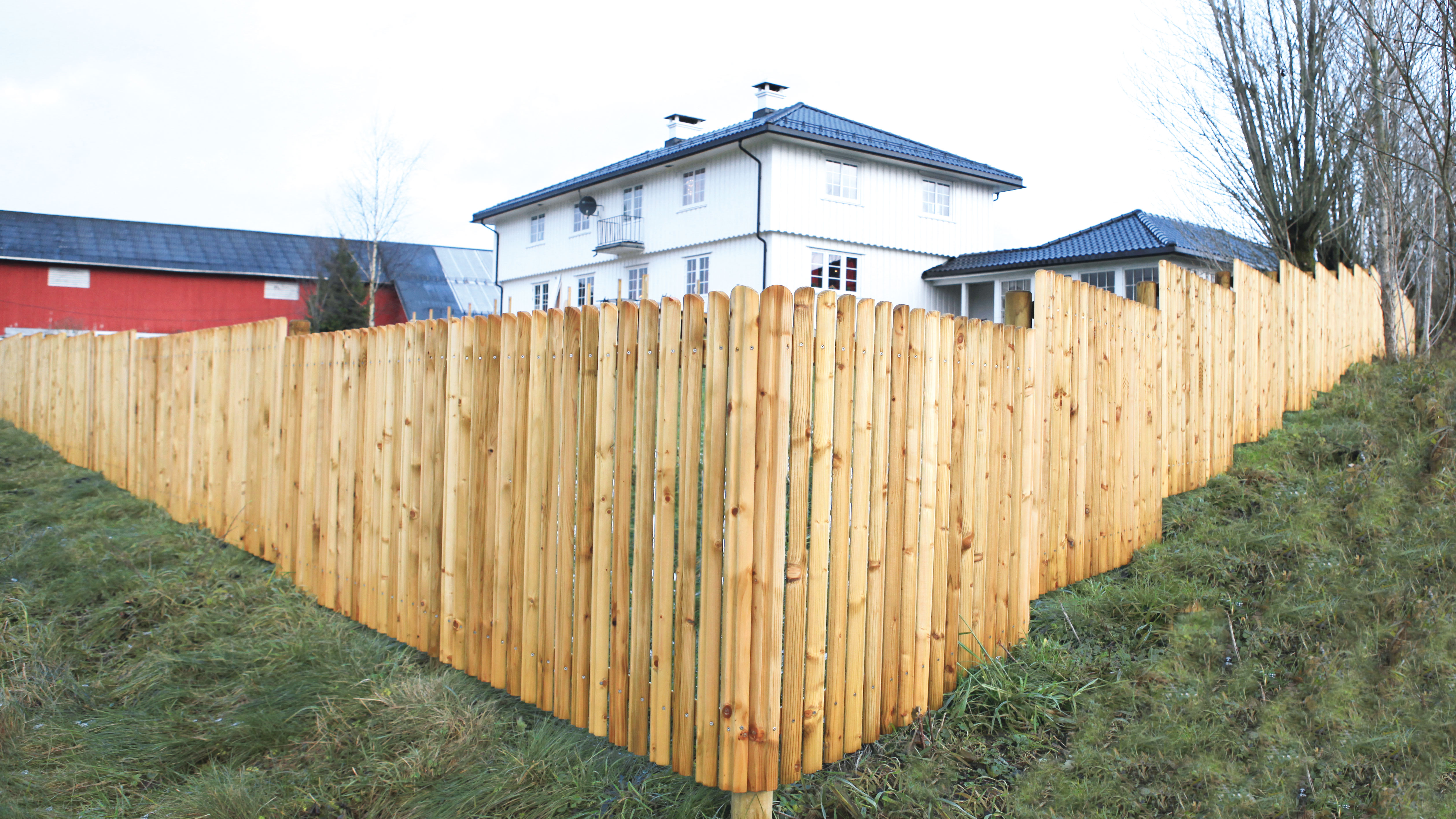 Et flot hegn i Terndrup-designet indhegner et stort hvidt hus