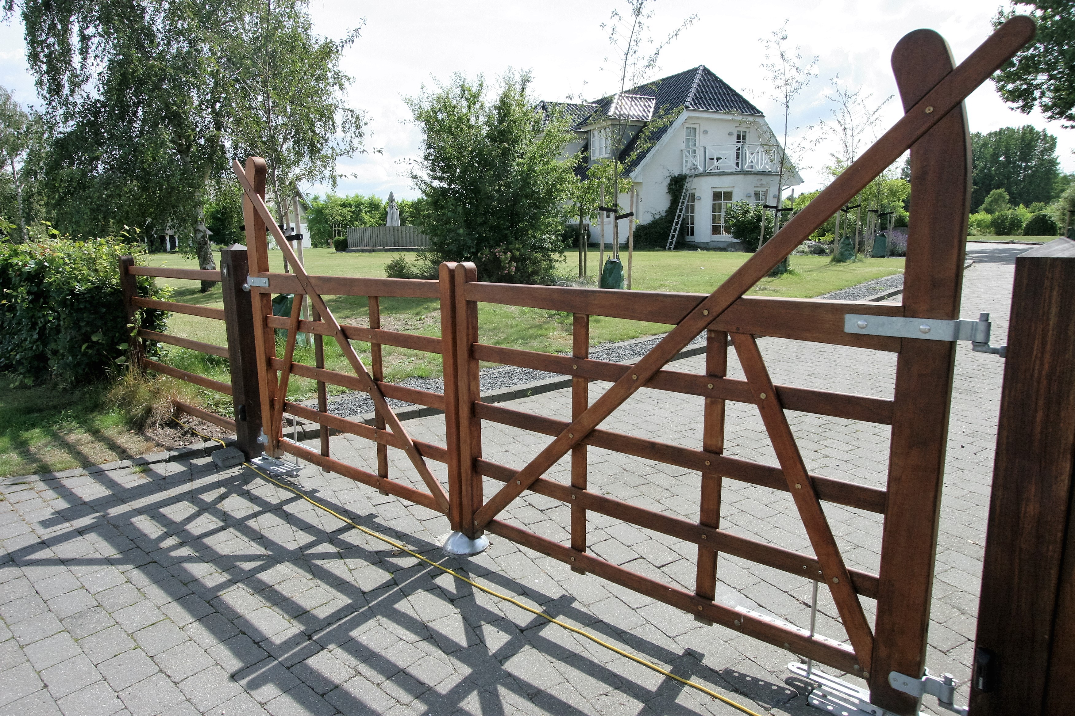 I en indkørsel er der en Country Ranger låge, i baggrunden er et hvidt hus